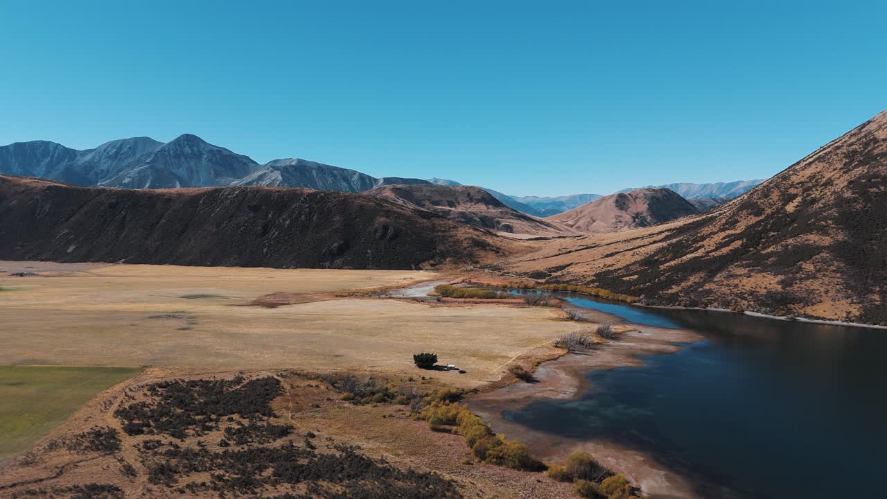 Serene aerial shot of Lake Pearson surrounded by golden hills and clear skies in autumn