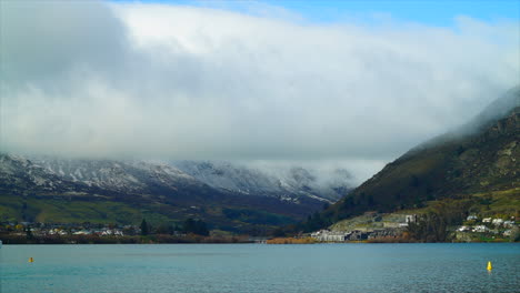 Wolken-Verbergen-Hohe-Berge-In-Queenstown,-Wo-Boote-In-Der-Bucht-Fahren