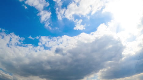huge white soft cloud lit by the bright sun changes its shape in the wind. cloudy sky in summer. view from below. timelapse.