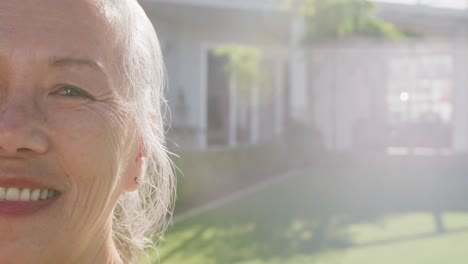 portrait of happy asian senior woman on sunny day in garden