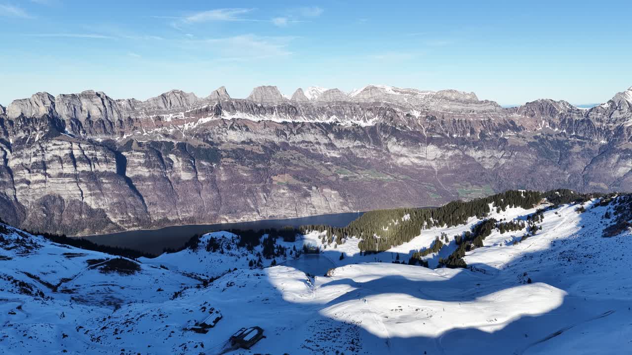 Snow covered alpine mountains and ridges overlooking Walensee in daylight