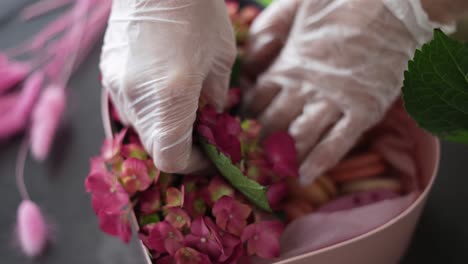 woman pastry chef putting flowers in a box