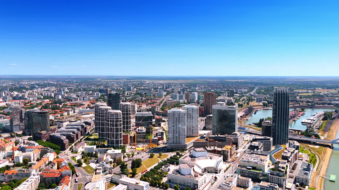 Clear Bratislava skyline view. A stunning view of Bratislava showcasing modern architecture and the Danube River under a bright blue sky