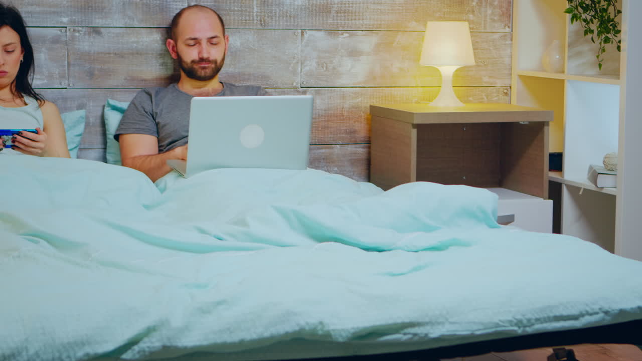 젊은 남자가 노트북에서 늦게 일하고 있습니다.