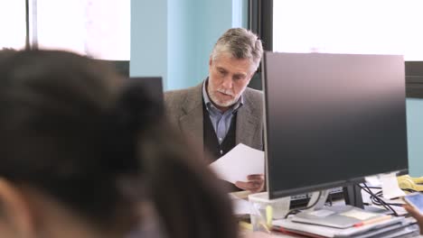 manager analyzing documents and using computer at coworking workspace