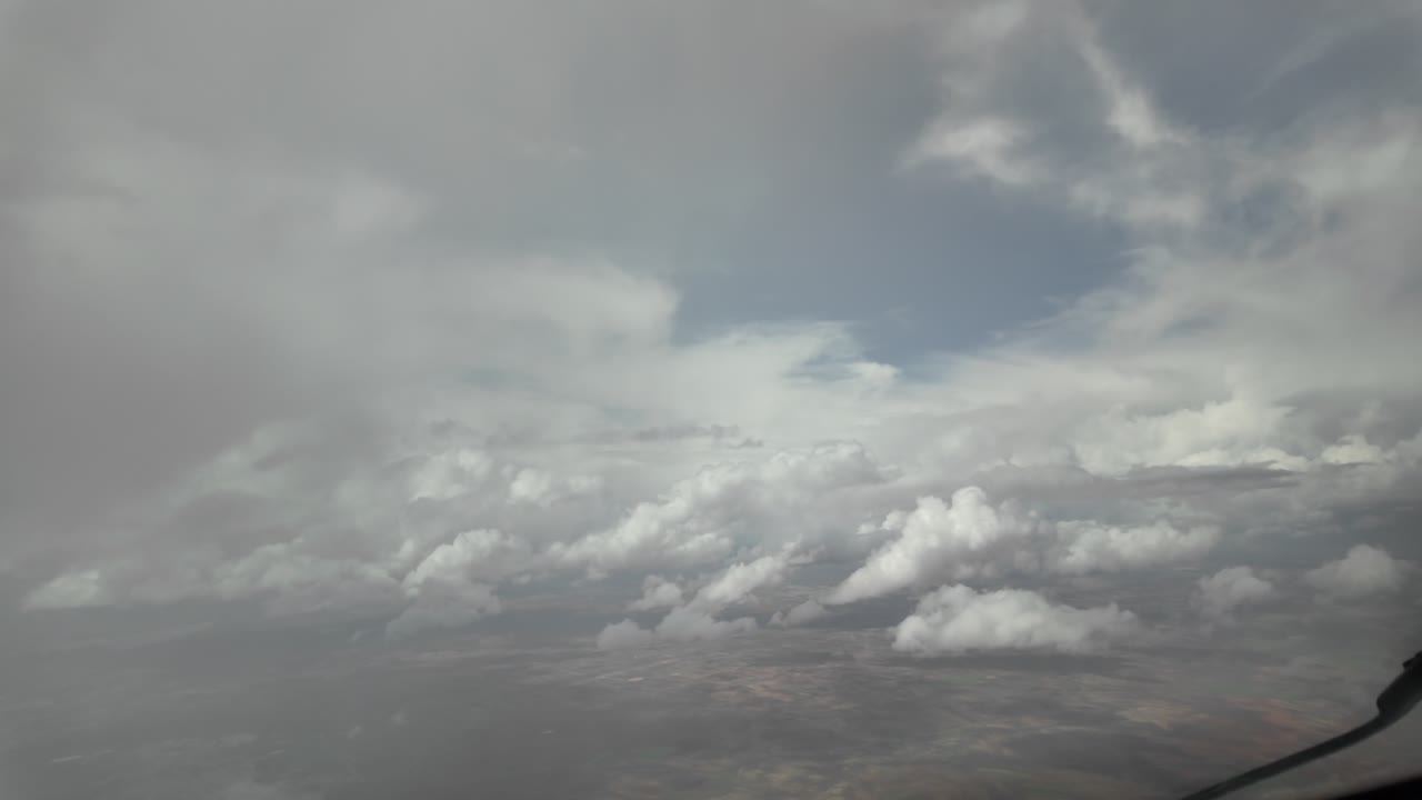 an immersive pilot’s perspective from cockpit flying through a storm cloud with rain and emerging from the clouds.