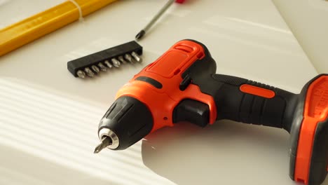 close up of a cordless drill and screwdriver bits on a white surface