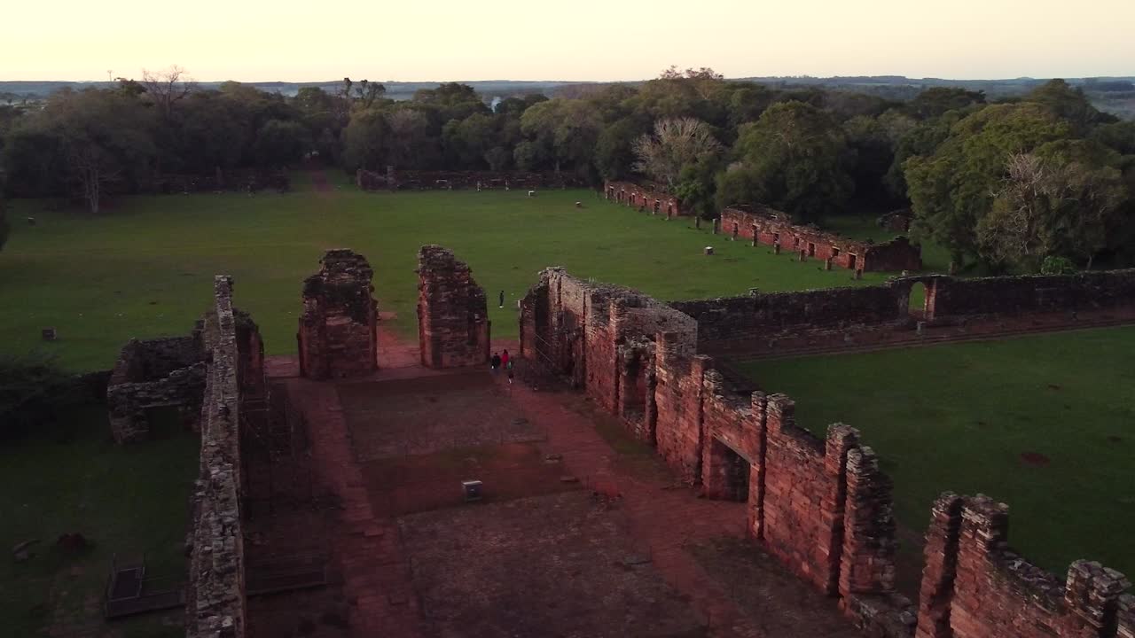 Panning aerial footage shot of the mission ruins of San Ignacio, Misiones, Argentina surrounded by a luscious green forest