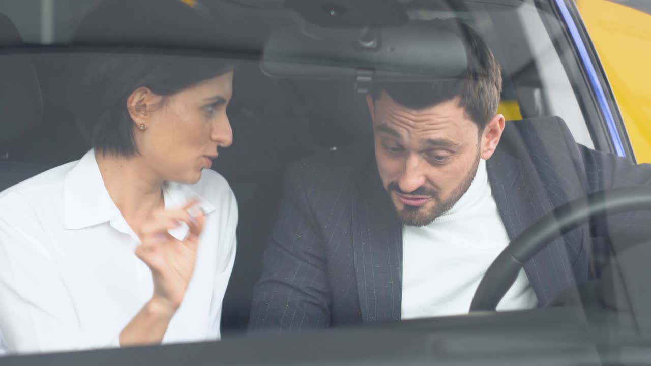 자동차 러에 앉아 여성 자동차 대리인과 대화하는 우아한 남자. 쇼에서 최고의 자동차를 선택하는 클라이언트를 돕는 전문