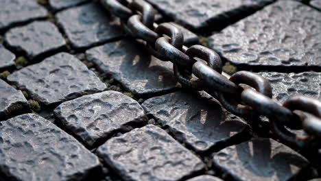 rusty chain on cobblestones