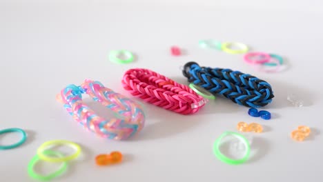 trabajo de bricolaje joven, pulsera de mano de banda de goma colorida y creativa sobre fondo blanco