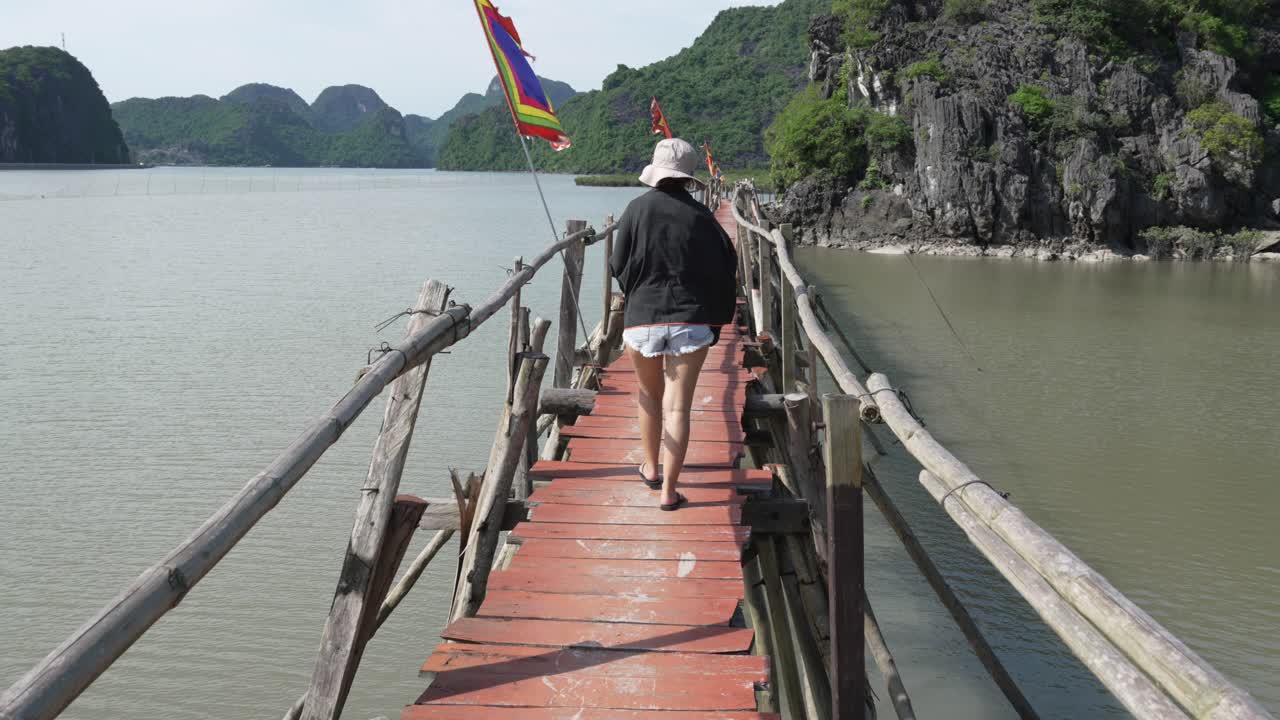 Walking over wood deck bridge Cat Ba national park Vietnam tourist outdoor destination