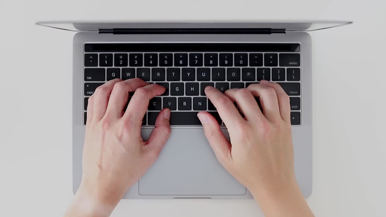 manos ocupadas escribiendo en el teclado del portátil