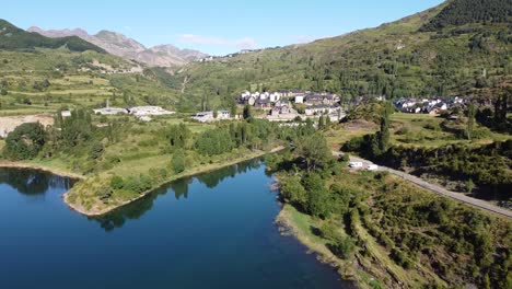 Vista-Aérea-De-Drones-Del-Pueblo-De-Montaña,-Lago-Embalse-De-Bubal-Y-Autocaravanas