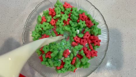 pouring milk over a bowl of cereal