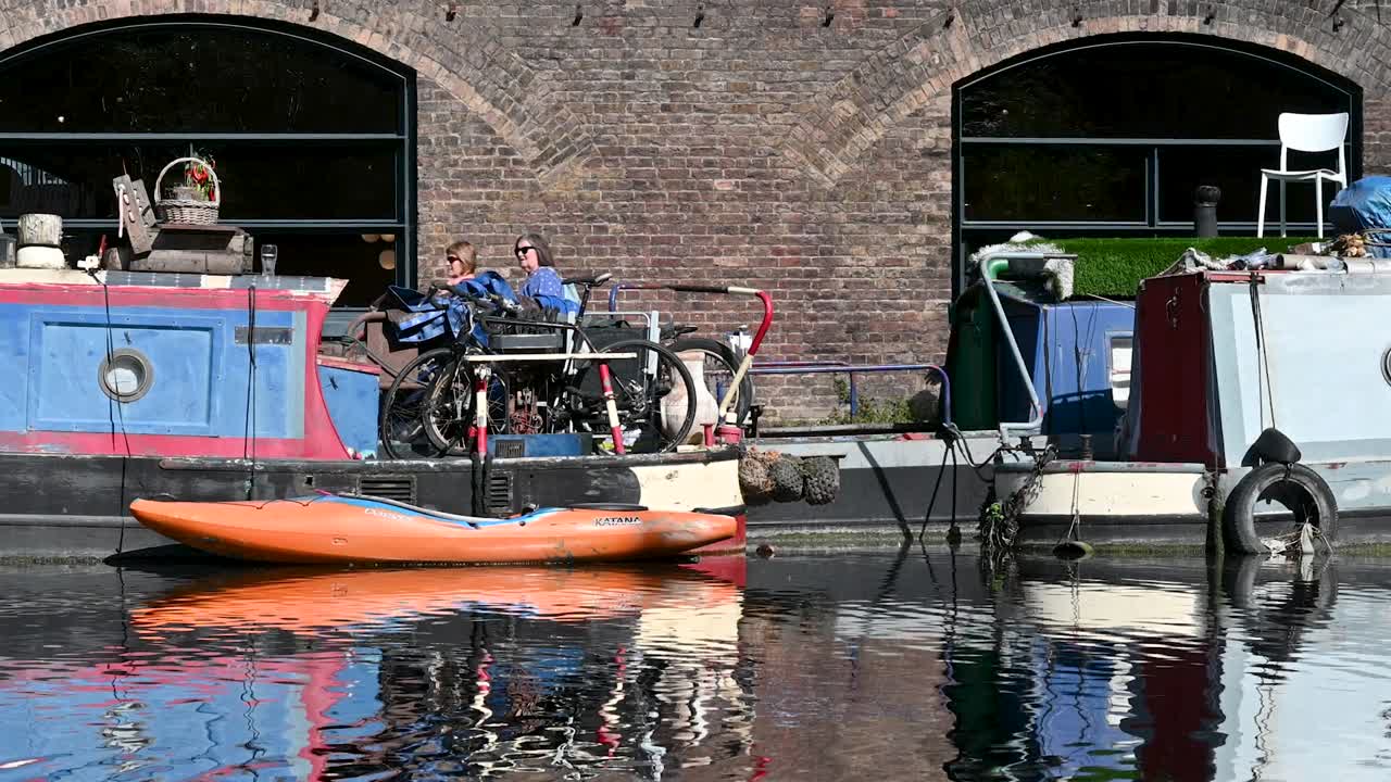 Many people walking past the canoe on Regents Canal, London, United Kingdom