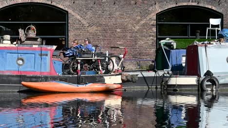 many people walking past the canoe on regents canal, london, united kingdom
