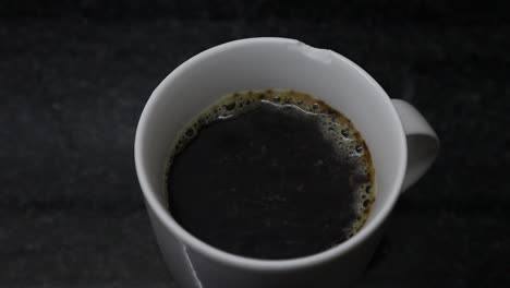 a hot cup of black coffee bubbling