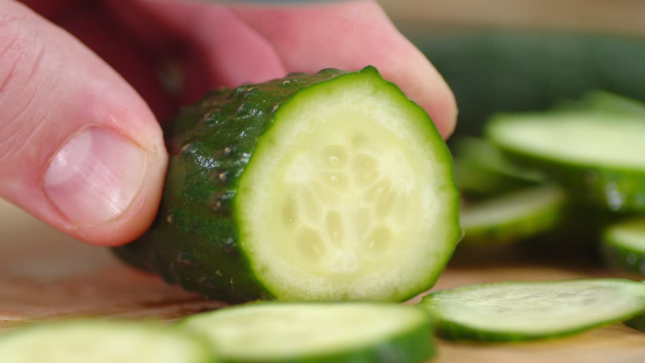 칼을 들고 있는 한 남자의 손은 자르는 보드 위에 호박을 잘라냈습니다.