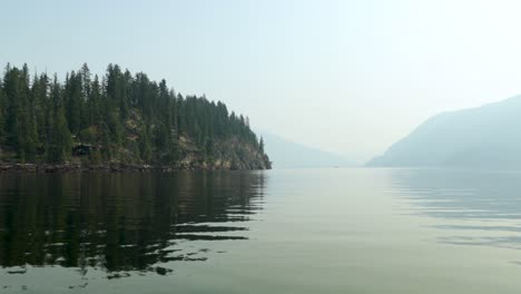 boating by rocky lake shore on the shushwap lake in the summer