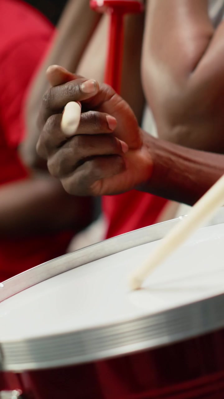Vertical Video Close up of soccer supporter using drum to unite red fan section in stadium