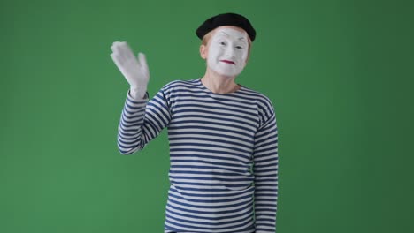 초록색 배경 위에서 손을 흔들고 있는 미미맨