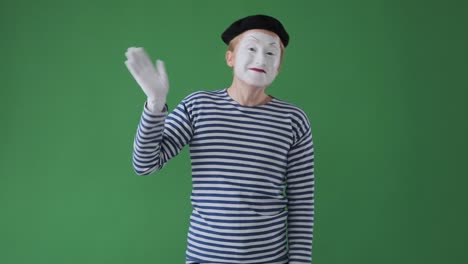 mime man waving hand over green background