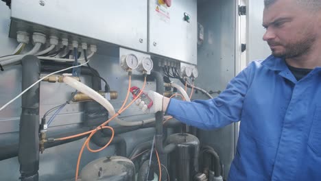 the technician checking power lines of the heat exchanger with current clamps