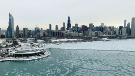 Vista-Aérea-Sobre-El-Lago-Helado-Michigan-Hacia-El-Parque-Grant-Y-El-Horizonte-De-Chicago,-Durante-Un-Día-Nublado-De-Invierno