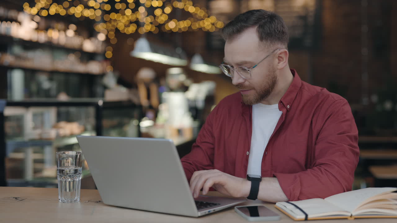hombre trabajando en una computadora portátil en un café