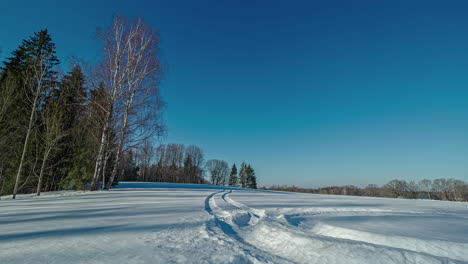 The-stunning-phenomenon-of-a-time-lapse-sunset-over-a-frozen-forest-lake-creates-a-captivating-visual-illusion,-enhanced-by-the-gentle-rays-of-sunlight