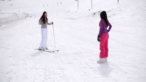 Young-woman-learning-to-ski-from-a-friend