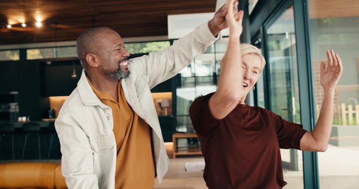 Happy Senior Couple Dancing Together in Modern Living Room