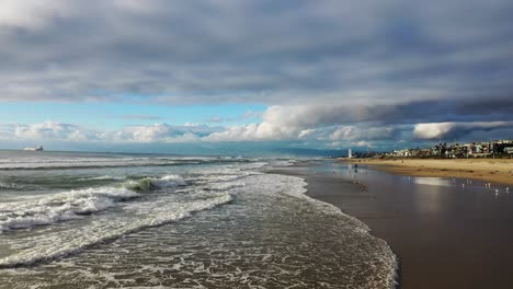 view of the waves crashing on the beach, motion bird's eye view of manhattan beach, california