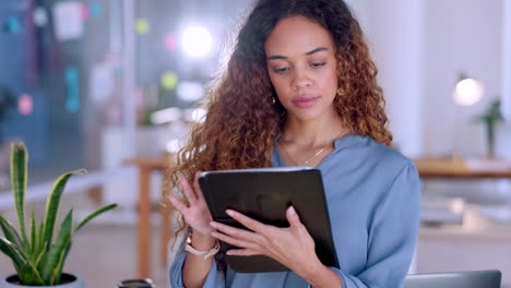 Serious-black-woman-on-tablet-in-office-for-online