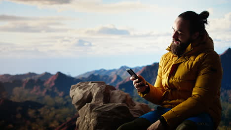 trekker enjoys a quiet moment in the mountains scrolling phone app