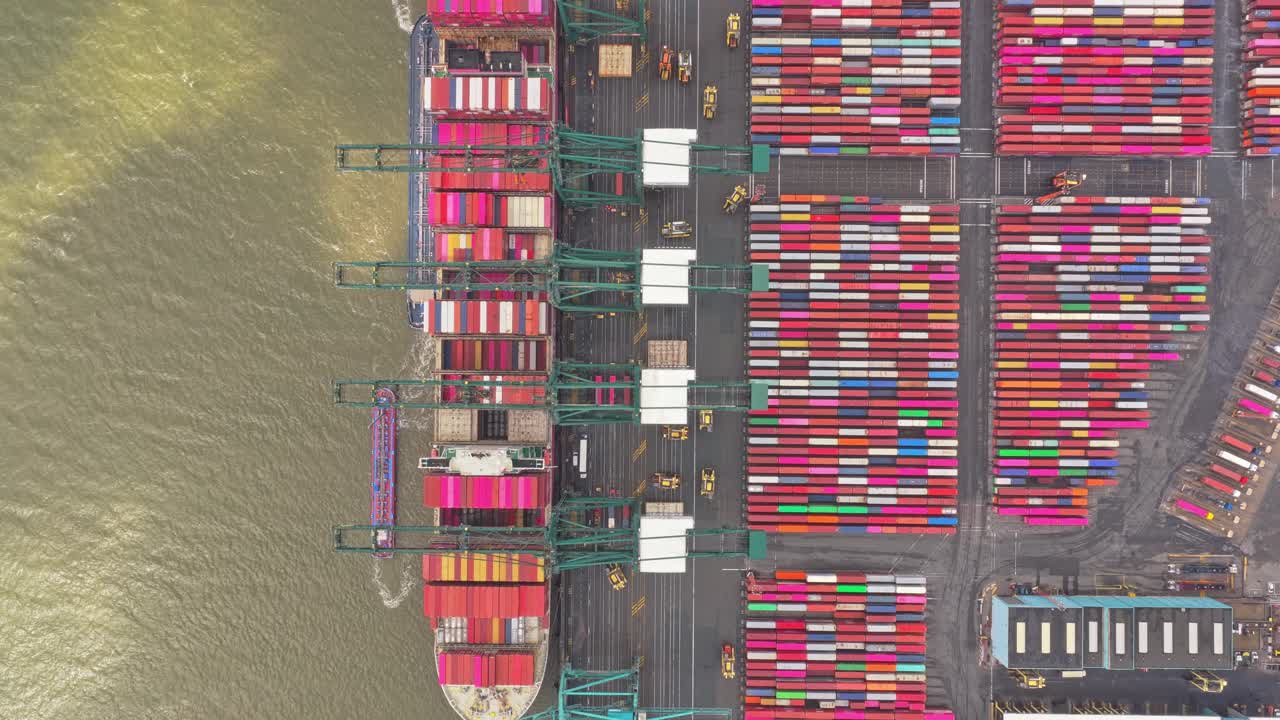 Aerial over Antwerp port with tank farms, vessels and cranes, Belgium