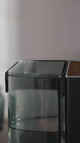 dama cierra el tanque de agua de la cafetera en el primer plano de la cocina. mujer finaliza el mantenimiento del fabricante antes de preparar una bebida aromática en casa. bebida casera