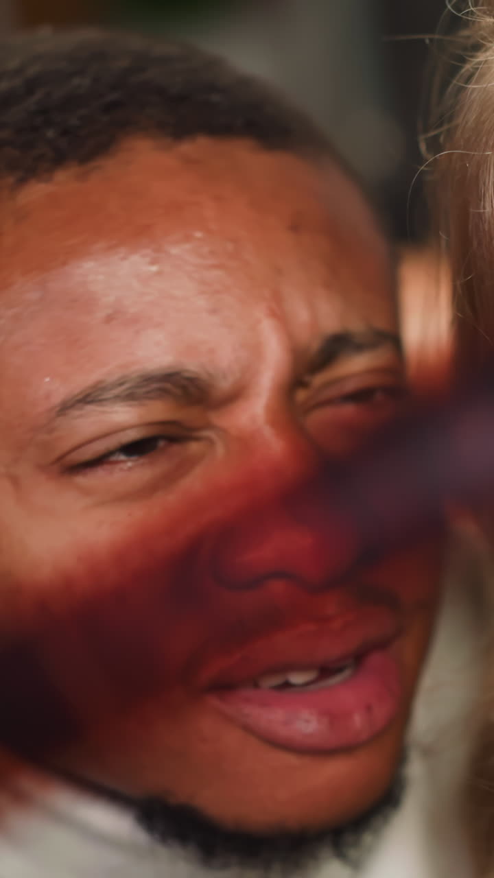 African-American photographer points to good shoot on processed coloured films roll to smiling blonde woman in studio closeup slow motion