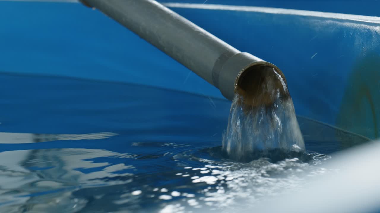 Close-up of filling a agricultural pond inside a fish production plant