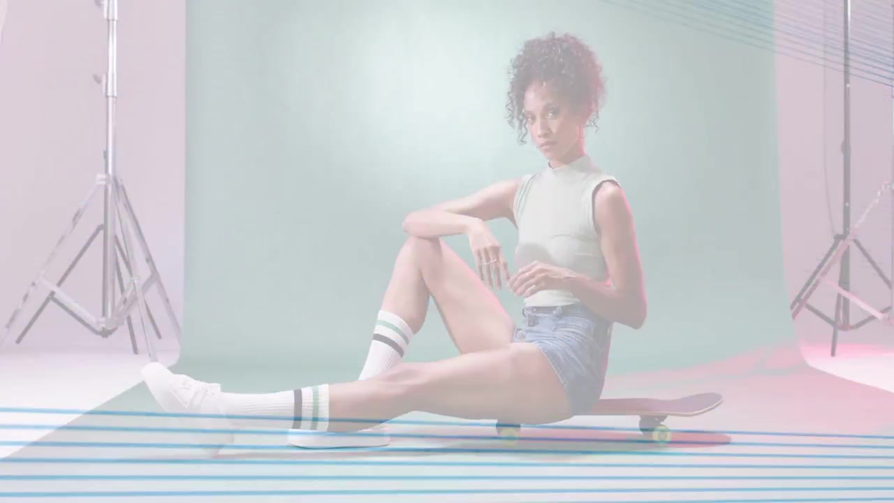 Scanlines clearing female model straightening smiling and posing on longboard in mint-green fashion