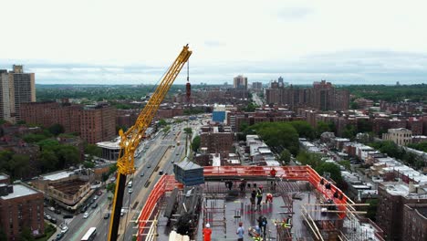 aerial view of a crane lifting rebar to the top of a building in queens, ny usa