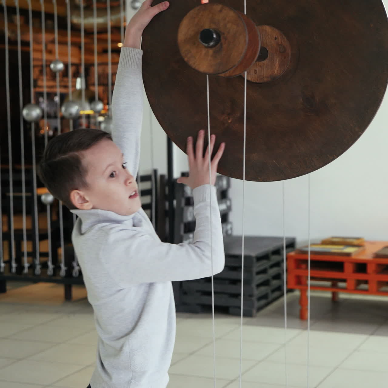 Mechanical conservation of energy. Maxwell's wheel. Boy conducts research experience. Square video