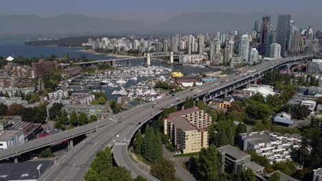 aerial panaramic hold over uptown vancouver seaside waterfront homes of false creek granville island west end kits 4 way river bridge to downtown on a sunny afternoon with horizon foggy mountain 4-4