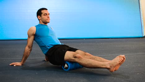 a-hand-held-shot-of-a-guy-using-a-massage-roller-with-only-his-bodyweight