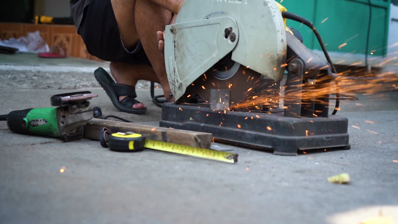 un trabajador de la construcción corta accesorios metálicos con una molienda.