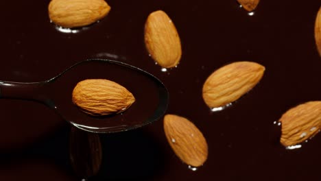 Melted-liquid-dark-chocolate-and-almond-rotating,-close-up-top-view-of-molten-liquid-hot-chocolate