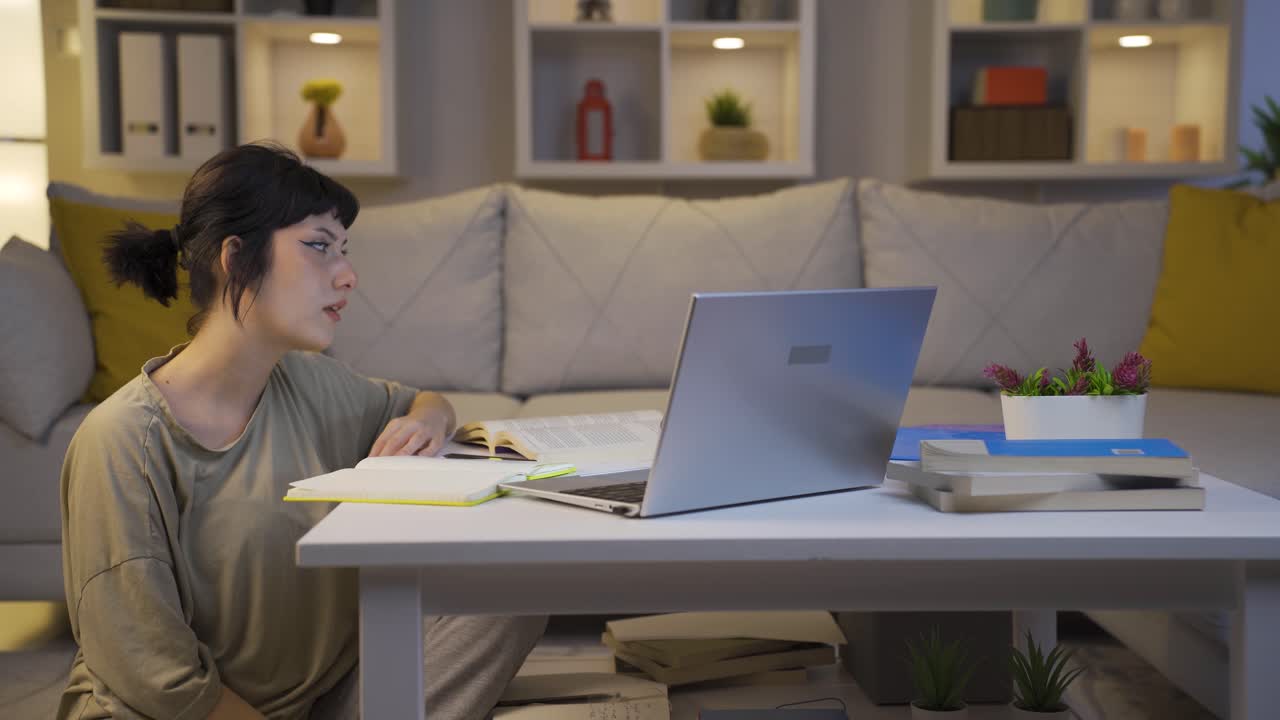 밤에 숙제를 끝내려고 하는 여자 학생.