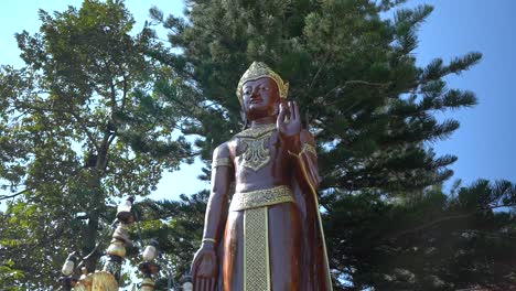 Budha-Statue-with-trees-in-the-background-on-a-Buddhist-Temple-in-Chiang-Mai,-Thailand