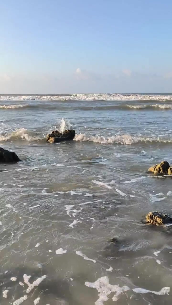 Onde oceaniche delicate che si infrangono sulle rocce su una spiaggia soleggiata